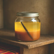 Bocal de rhum caramel beurre salé scellé sur étagère bois, avec gousse de vanille visible